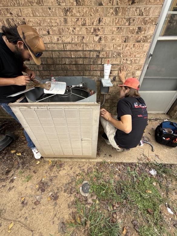 Technician servicing an outdoor AC unit